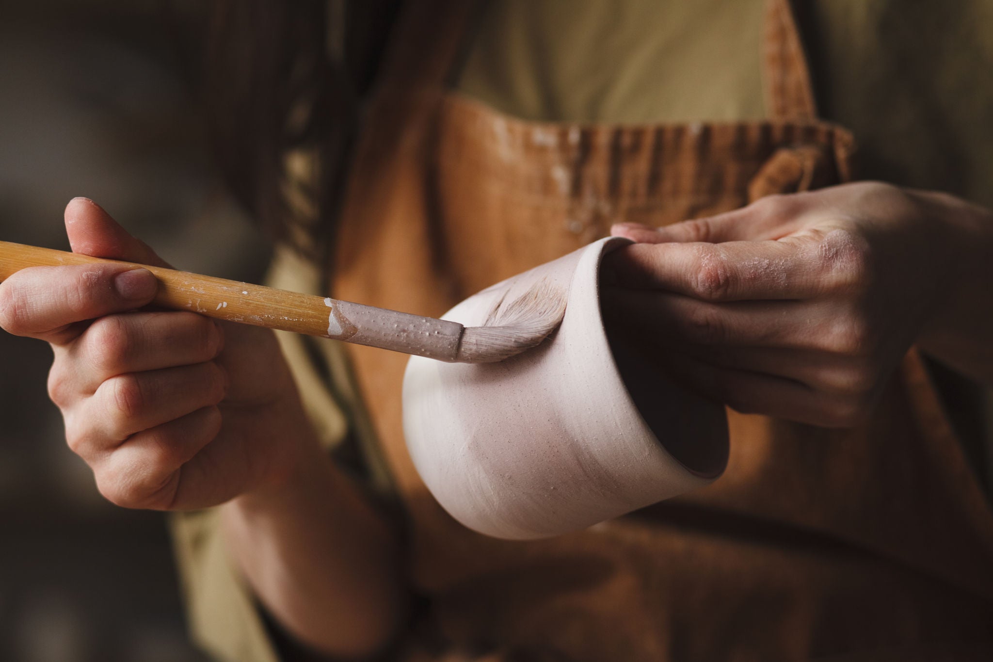 Pottery making, Female potter hands glazing clay cup